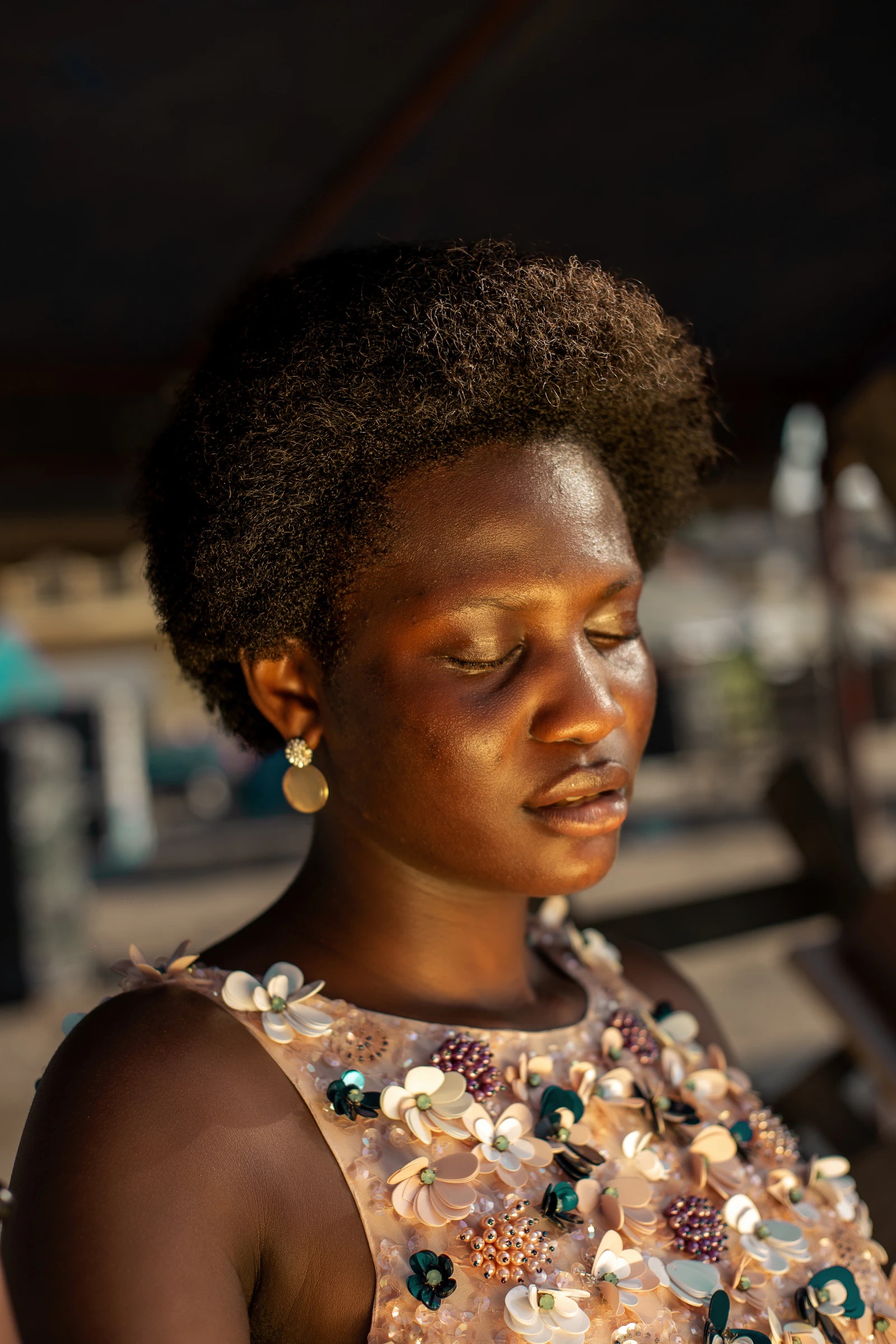 Femme aux cheveux naturels, yeux fermés, dans une lumière chaude