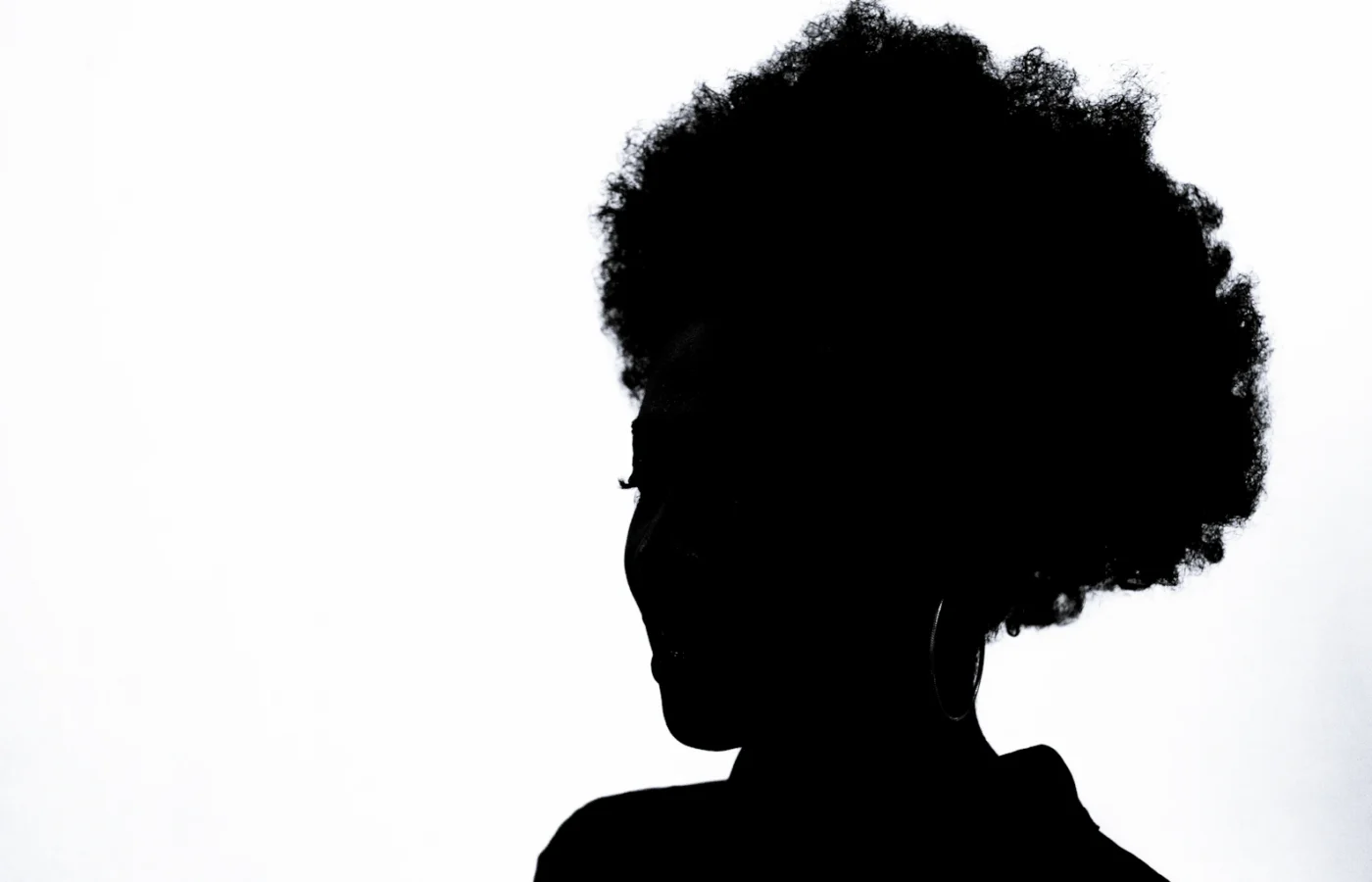Silhouette de dos d'une femme coiffée d'un afro naturel