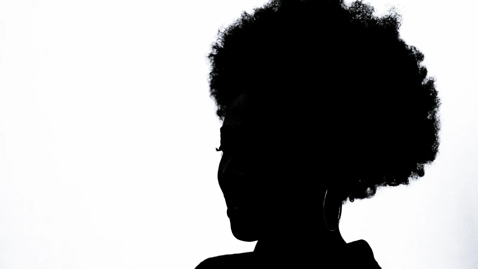 Silhouette de dos d'une femme coiffée d'un afro naturel